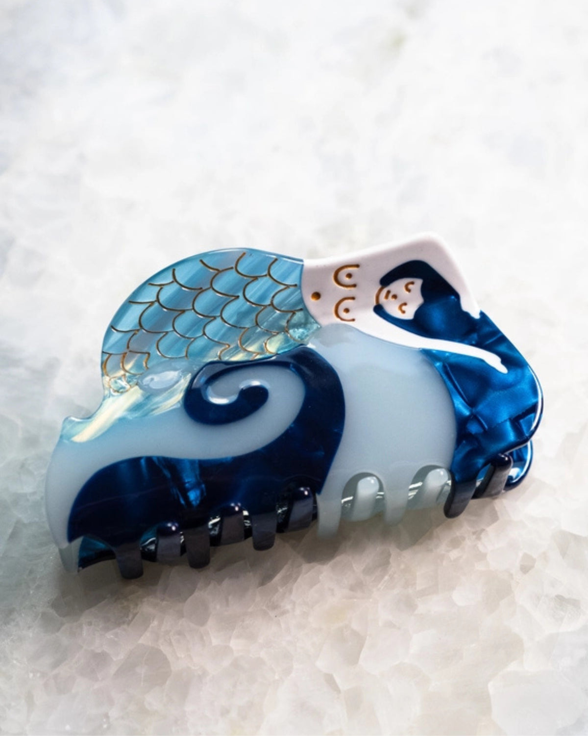 Blue and white mermaid-shaped hair clip shown from the side