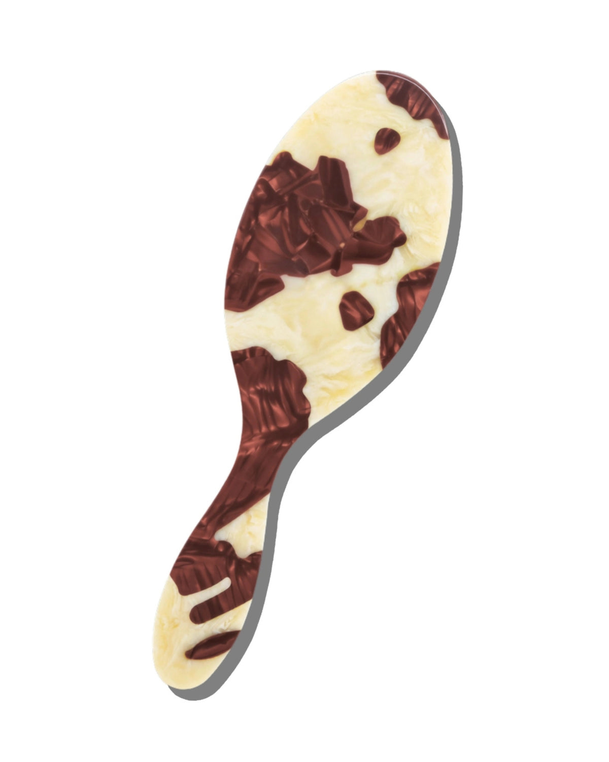 Single hair brush with an irregular oval silhouette and brown-and-cream cowhide-style painted pattern, shown on a white background.