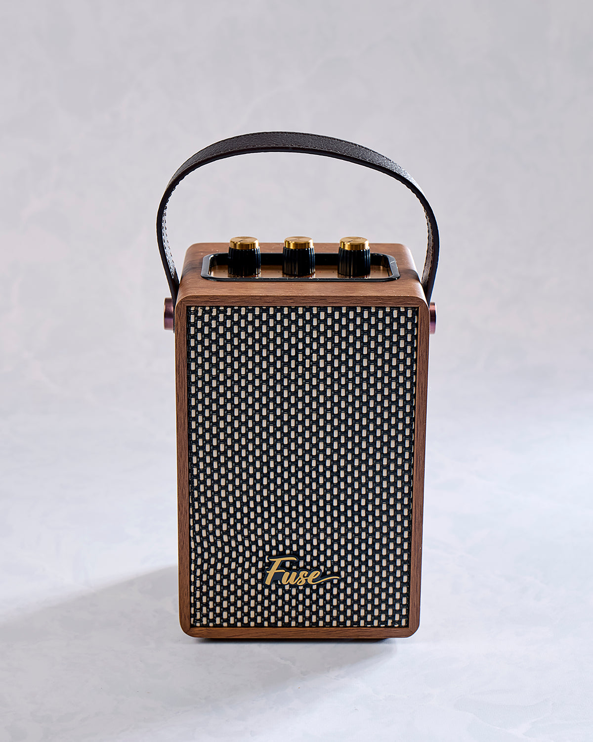 Front view of the brown handled speaker with a black woven grille and Fuse logo.