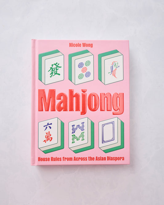 Pink hardcover Mahjong book by Nicole Wong, with illustrated mahjong tiles on the cover.