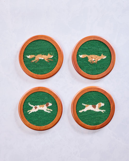 Four round Fox Chase coasters with embroidered fox motifs on green centers and chestnut-colored wooden rims.