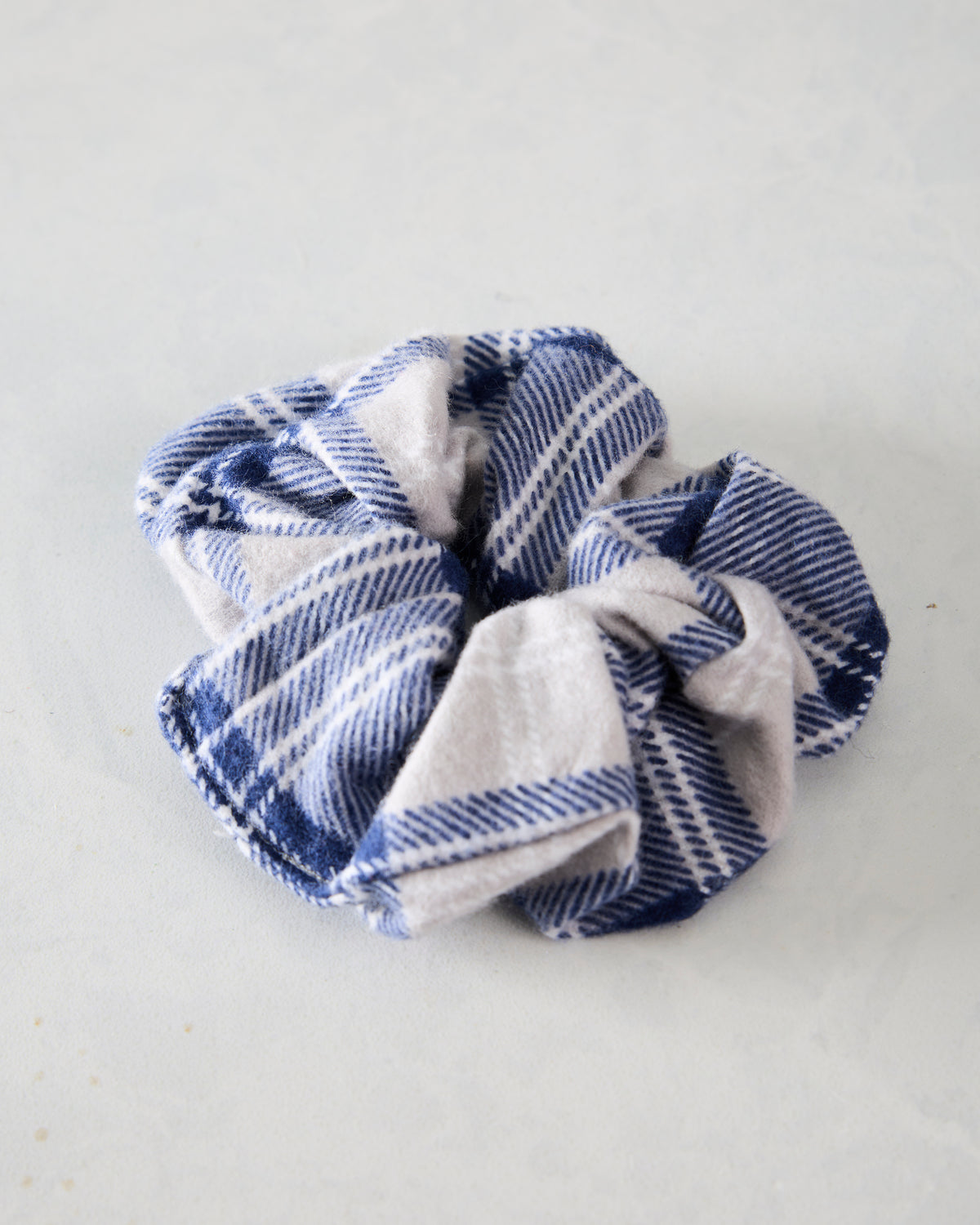 Blue and cream plaid flannel scrunchie shown from above.