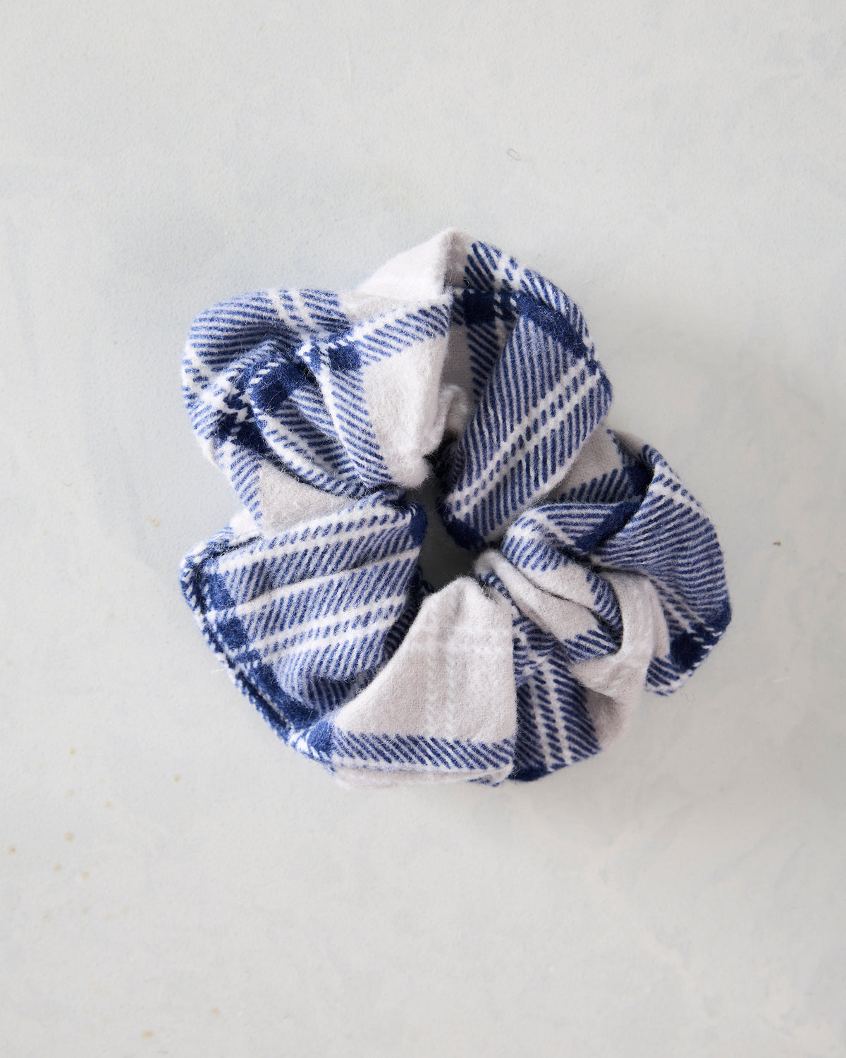Blue and cream plaid flannel scrunchie shown from a slightly angled view.