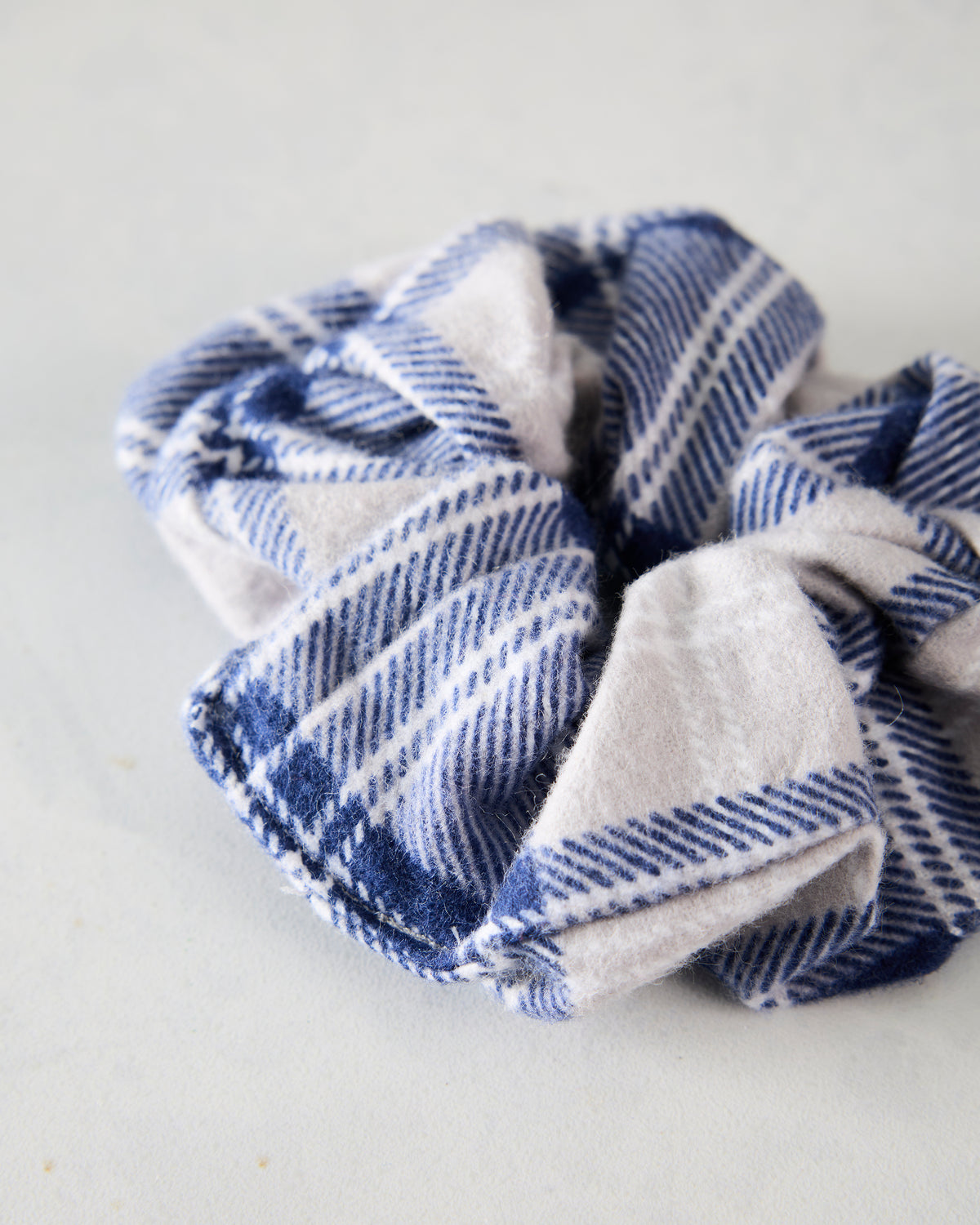 Close-up of the blue and cream plaid flannel scrunchie.