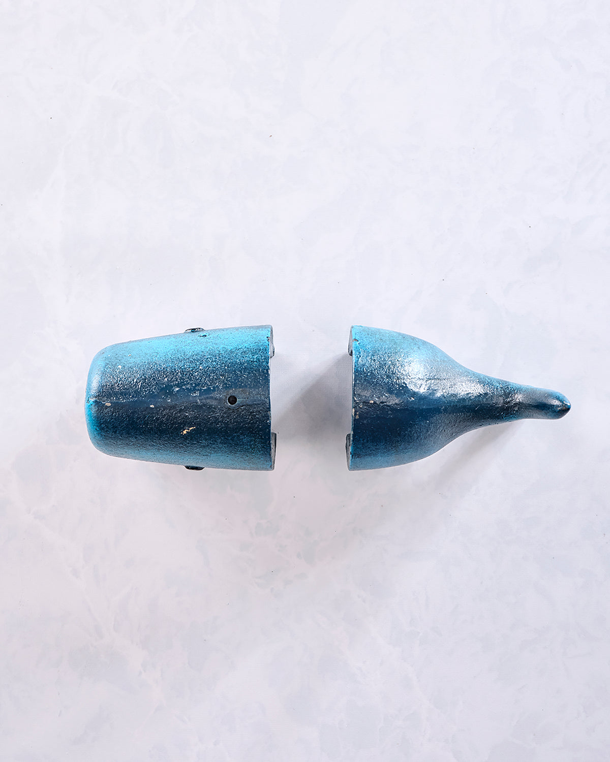Top view of two separate gray whale-shaped bookends facing each other.