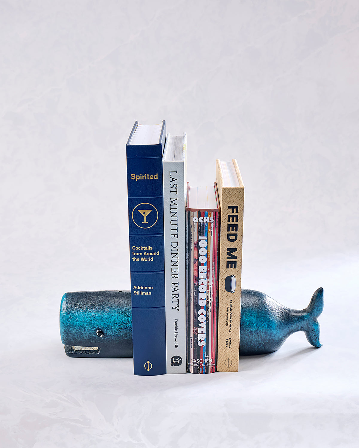 Books arranged between whale-shaped bookends, including a blue whale-shaped bookend visible behind the books.