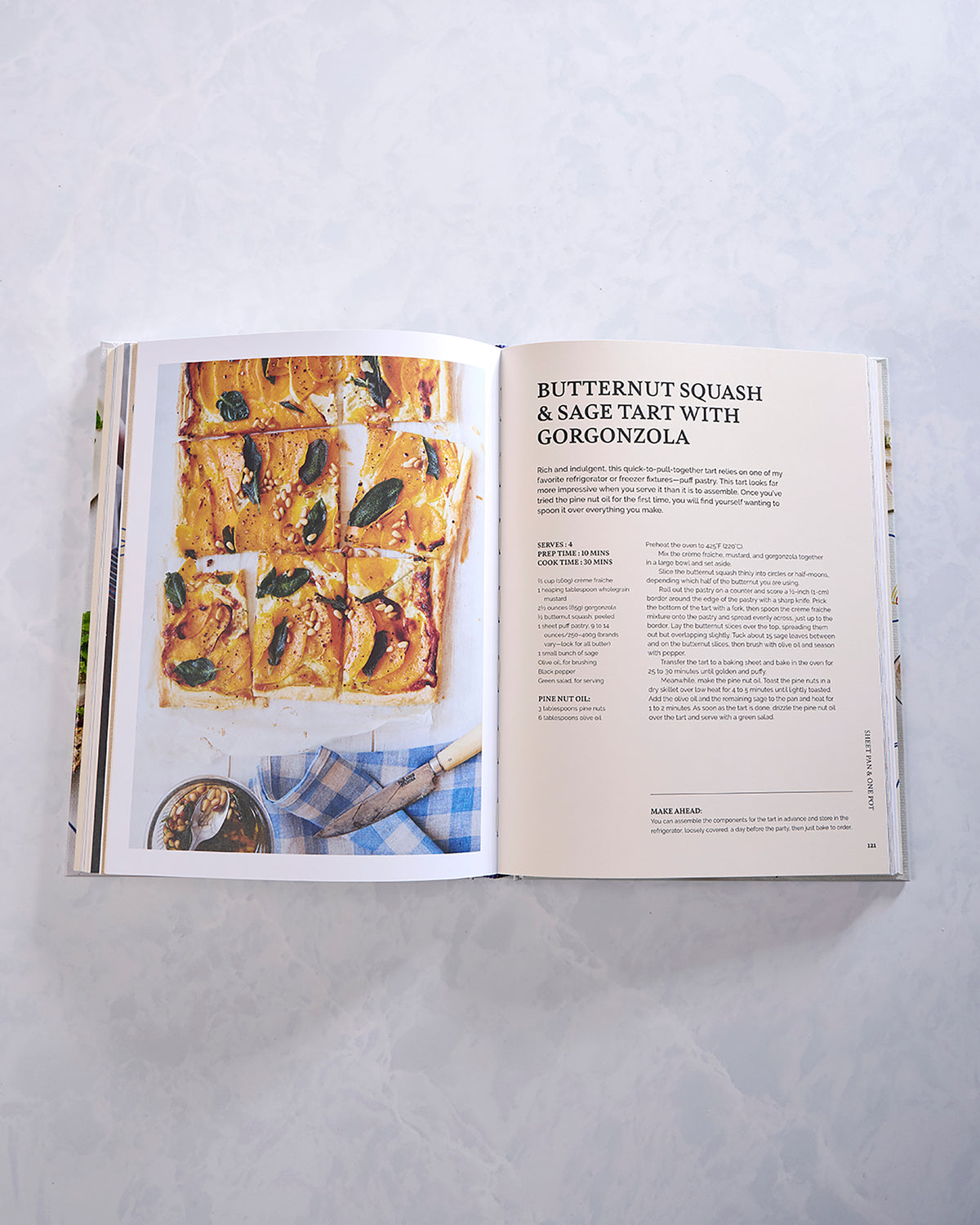 Open cookbook showing a roasted squash dish on the left and the recipe titled “Butternut Squash & Sage Tart with Gorgonzola” on the right.