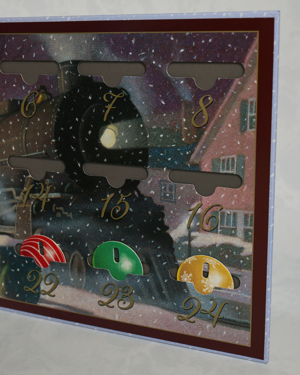 Close-up of the Polar Express countdown calendar showing numbered ornament pockets and several colored ornaments, including dates 6 through 8 and 22 through 24.