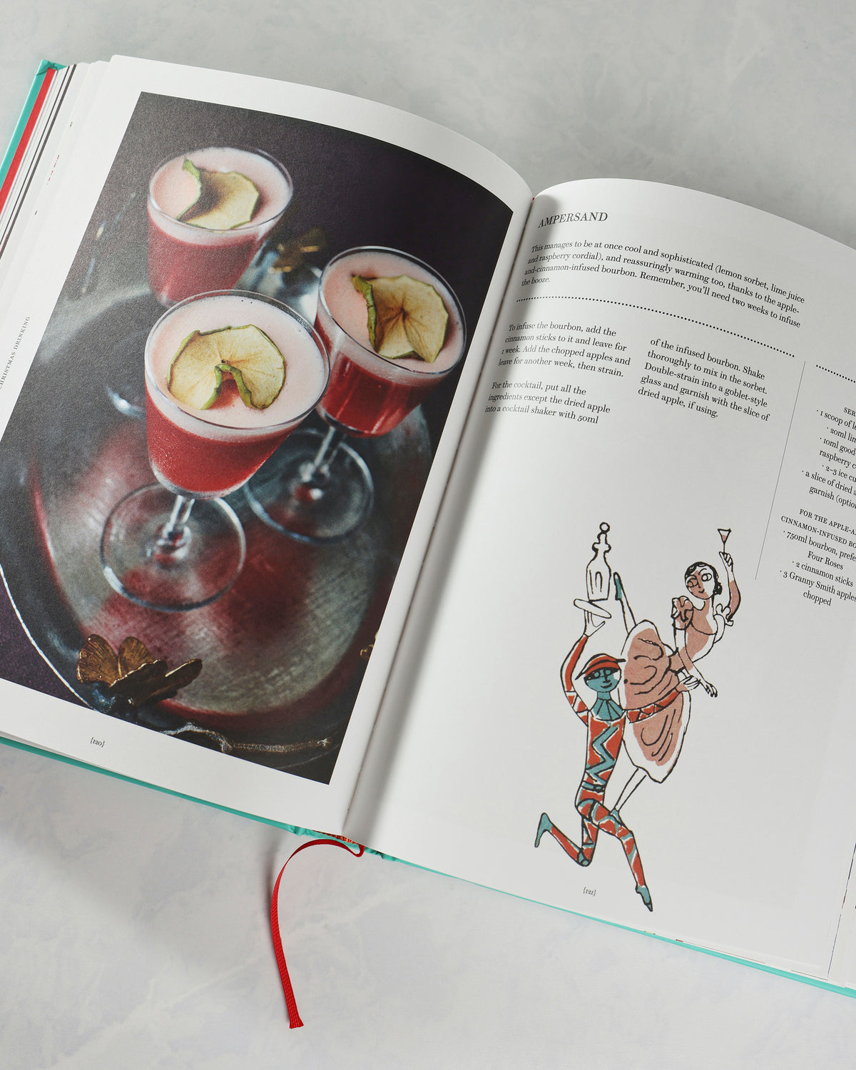 Open Christmas and Other Winter Feasts cookbook showing cocktails on one page and an illustrated dancing couple beside the heading “Ampersand.”