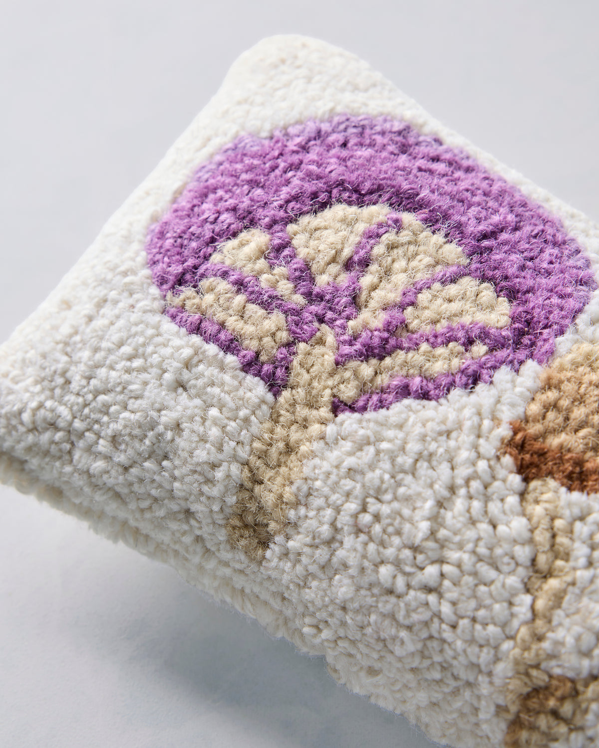 Close-up of the purple mushroom design and textured ivory pillow surface.
