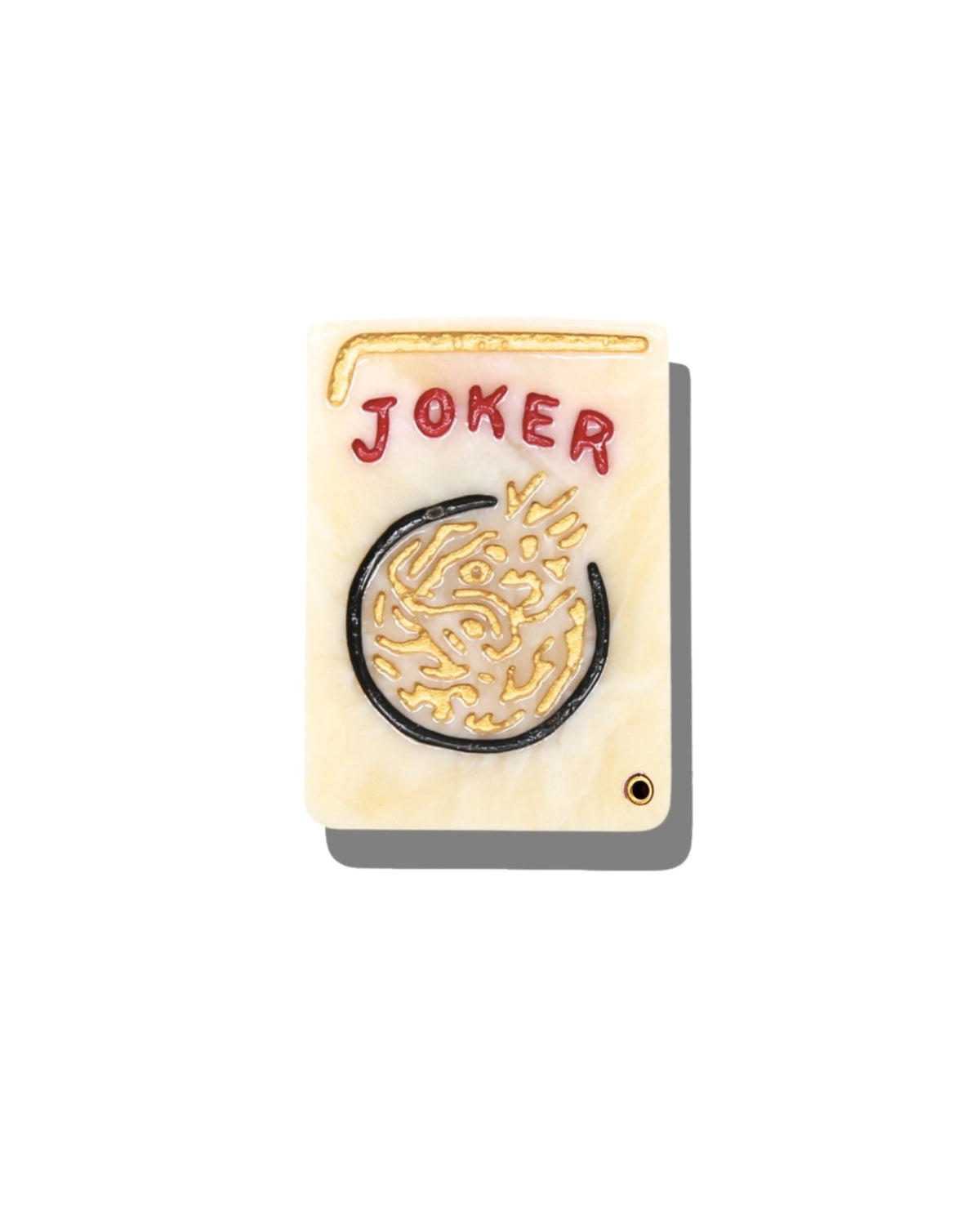 Closed ivory compact mirror with a circular black, gold, and red Joker design