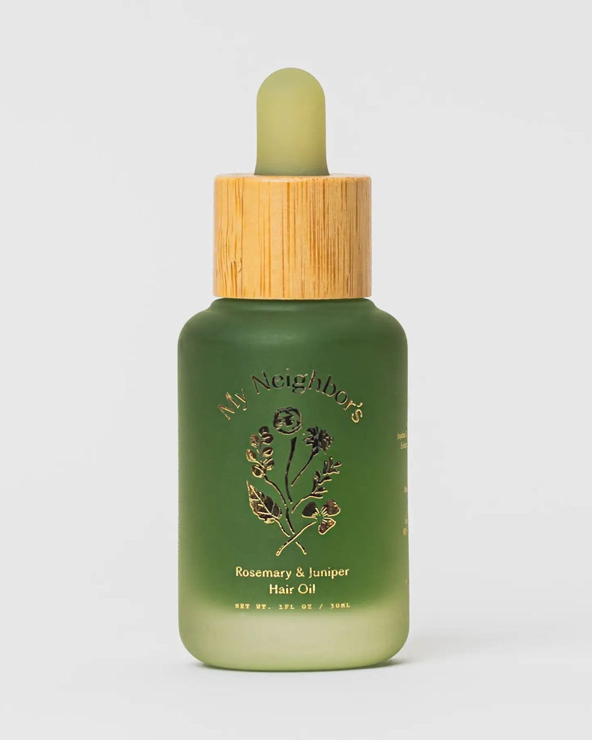 Frosted green dropper bottle of My Neighbor's Rosemary & Juniper Hair Oil on a light background.