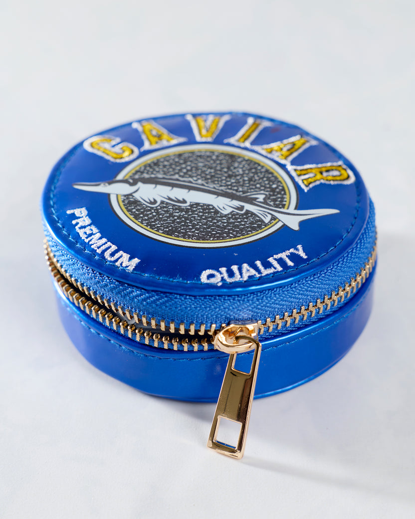 Closed blue round pill case shown at an angle with a fish graphic, gold-colored zipper, and zipper pull.