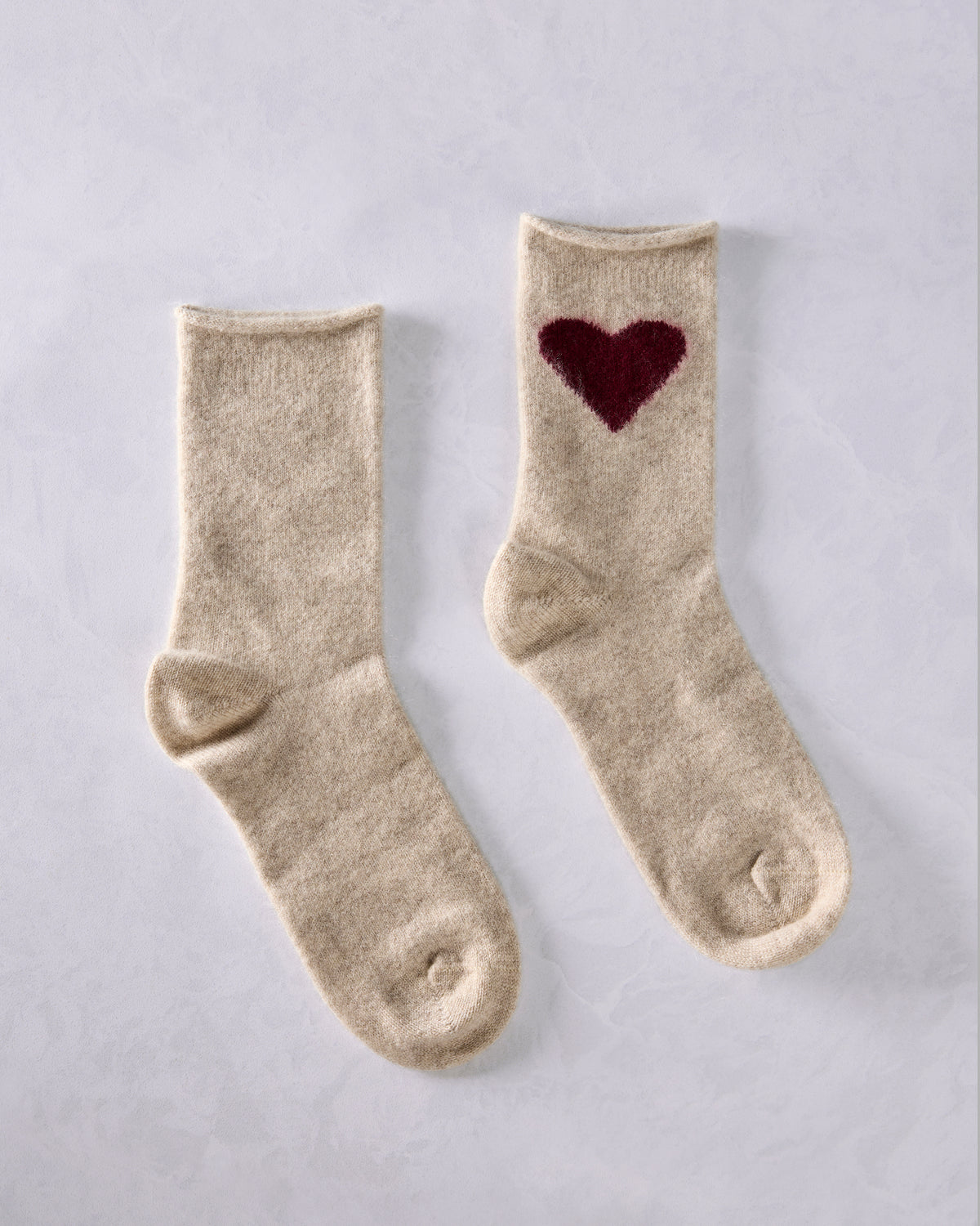 Pair of cream crew socks, with a burgundy heart motif visible on one sock.