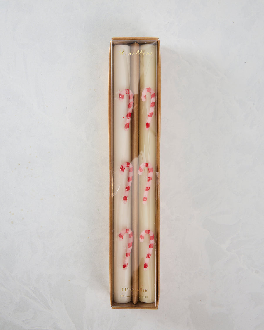 Boxed set of four white table candles with pink and red candy-cane stripes.