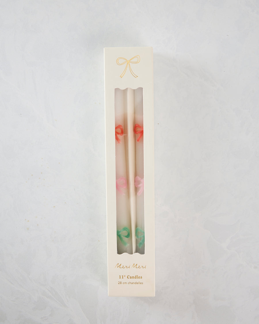 Boxed set of white taper candles with orange, pink, and green bow details; packaging reads “Meri Meri,” “11” Candles,” and “28 cm chandelles.”