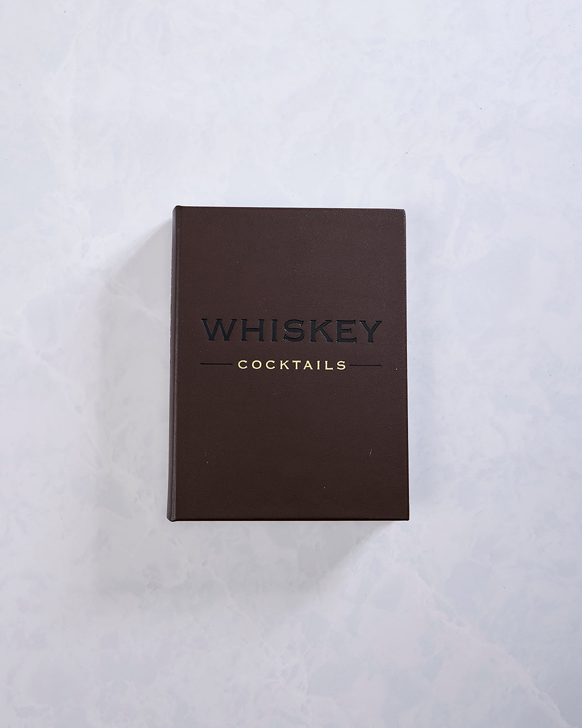 Mocha brown hardcover book titled “Whiskey Cocktails,” shown from the front.