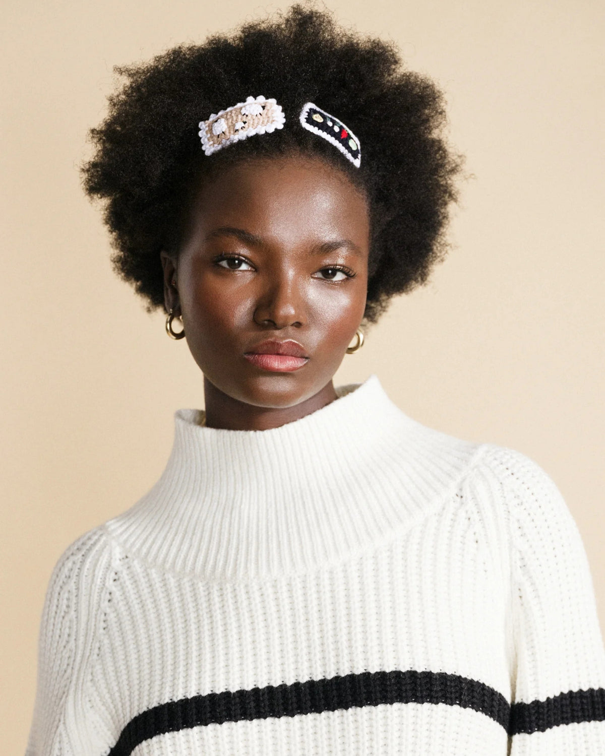 Close-up of a person wearing two crochet hair clips, including a vegetable-themed clip.