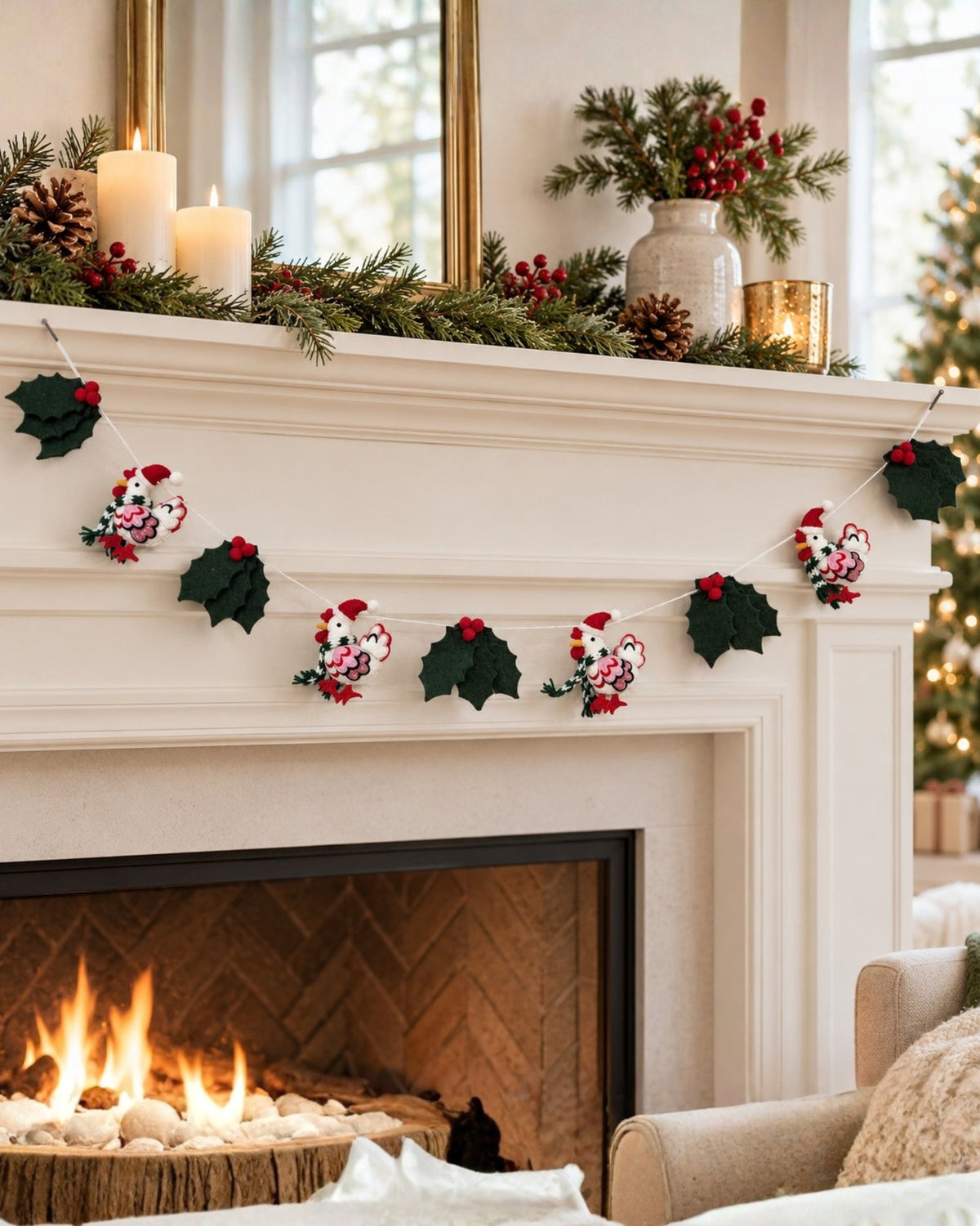 Holiday hens garland with four Santa-hat figures, holly leaves, and red berries draped across a white fireplace mantel.
