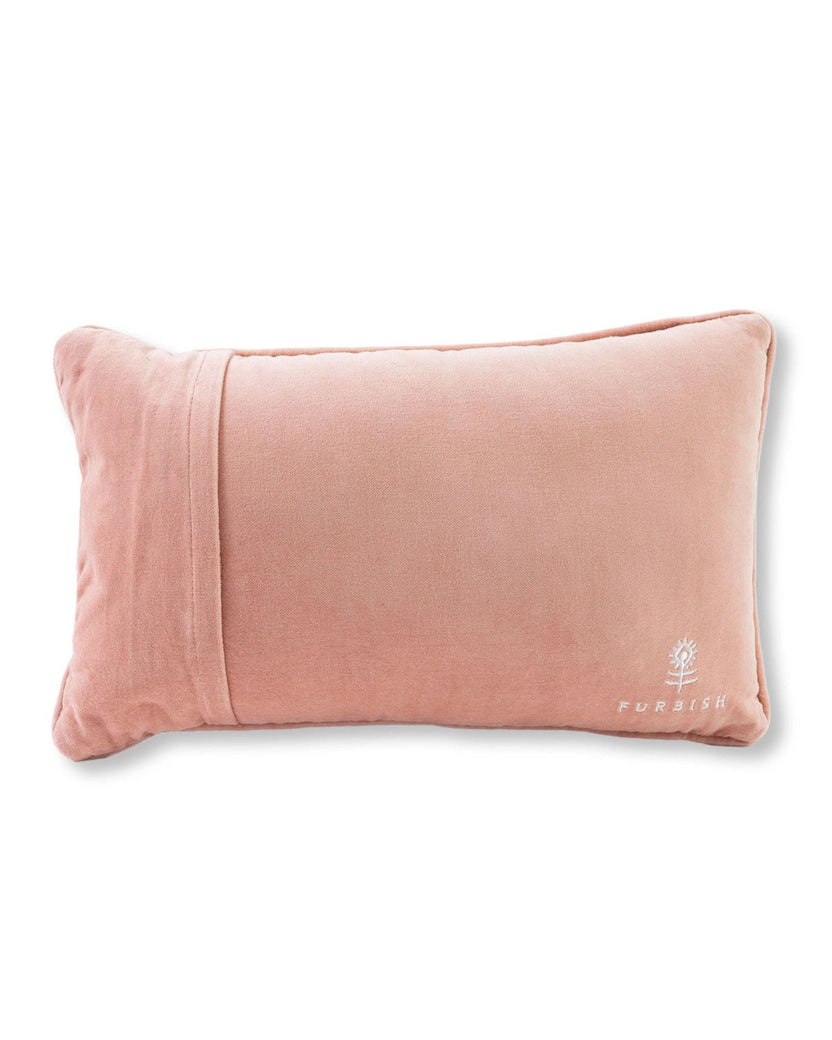Reverse side of a rectangular pale pink pillow with a Furbish logo in the lower-right corner.