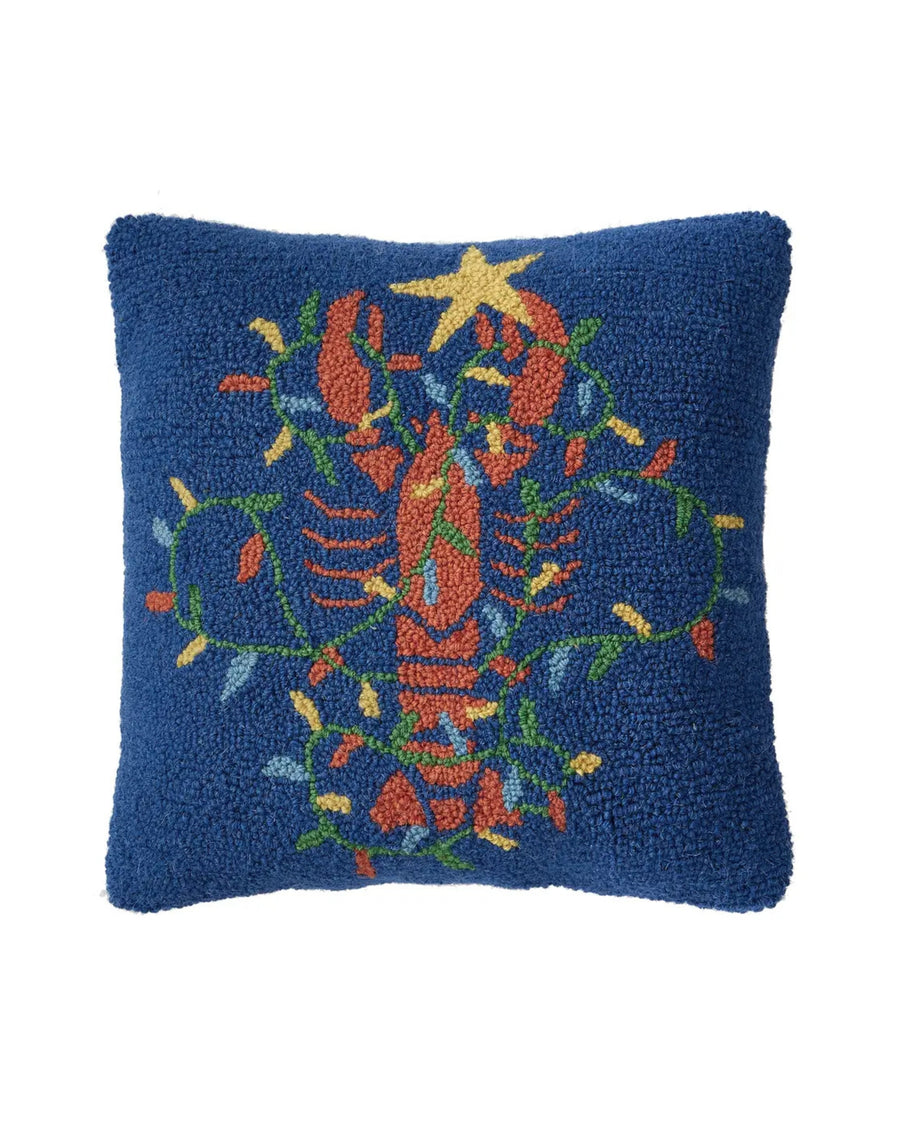 Front view of a navy hooked pillow with a colorful lobster surrounded by leafy botanical accents and topped with a star.