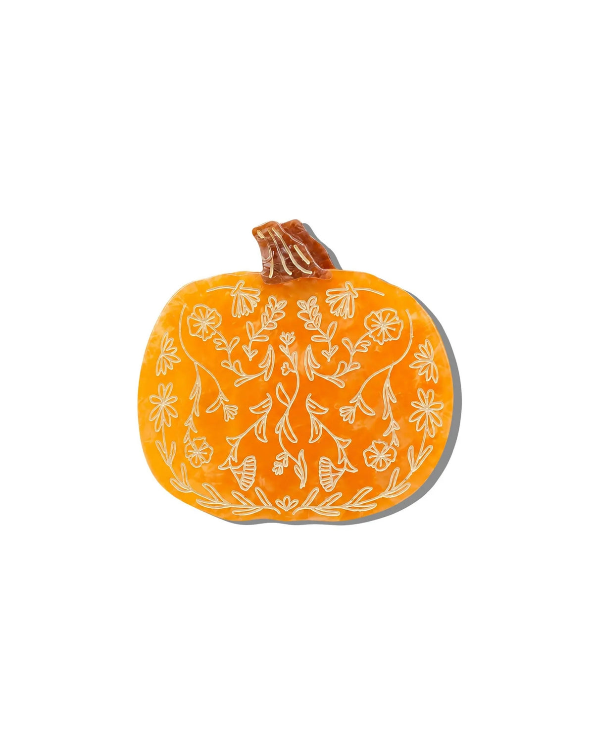 Front view of an orange pumpkin-shaped claw hair clip with an outlined floral pattern.
