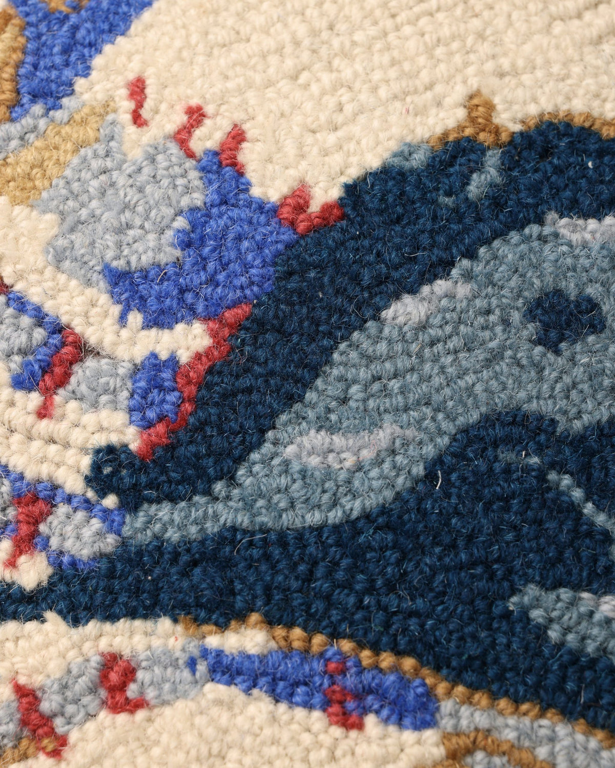 Close-up of the hooked blue crab pillow’s textured crab design.