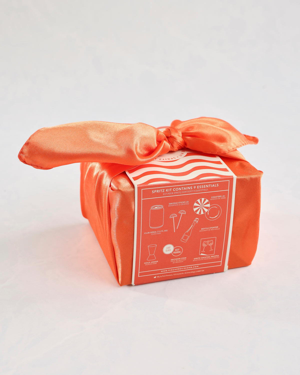 Orange-wrapped Spritz Kit gift set with a tied fabric bow and an illustrated contents panel.