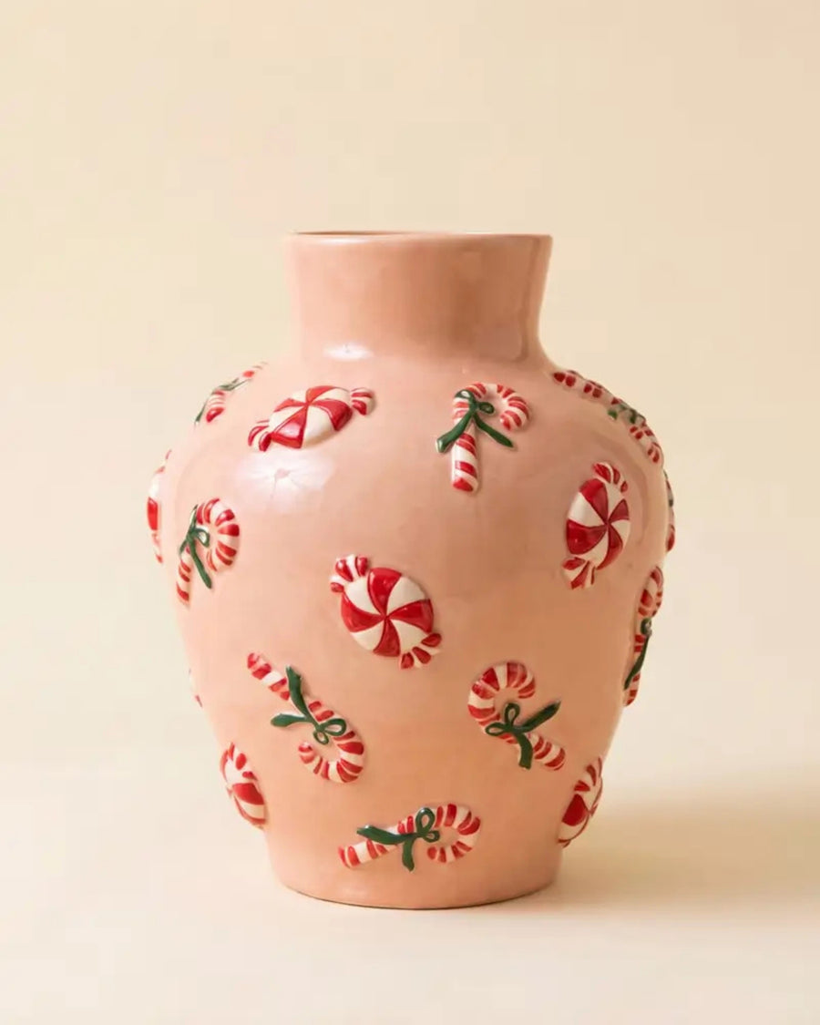 Pink ceramic vase with dimensional red-and-white peppermint and candy cane decorations