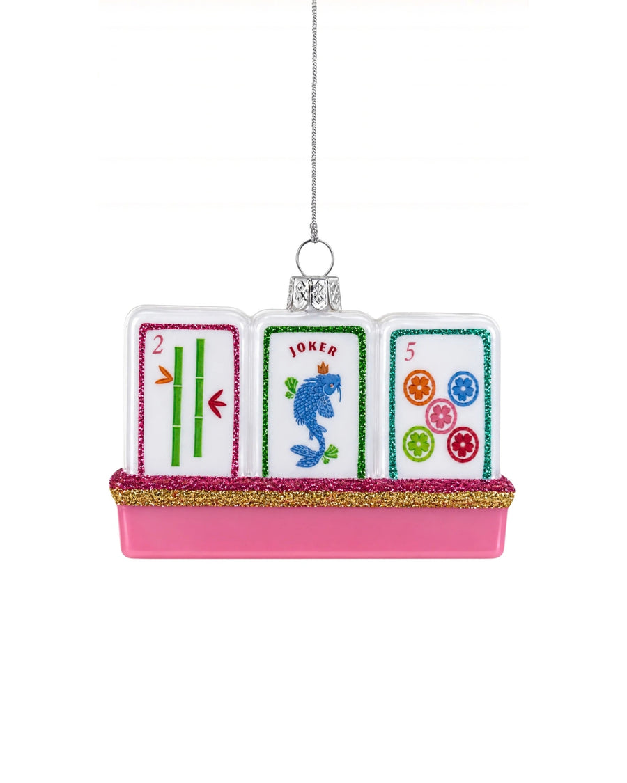 Glass mahjong tile ornament with three illustrated tiles, including tiles marked 2, JOKER, and 5, on a pink glitter-trimmed base.