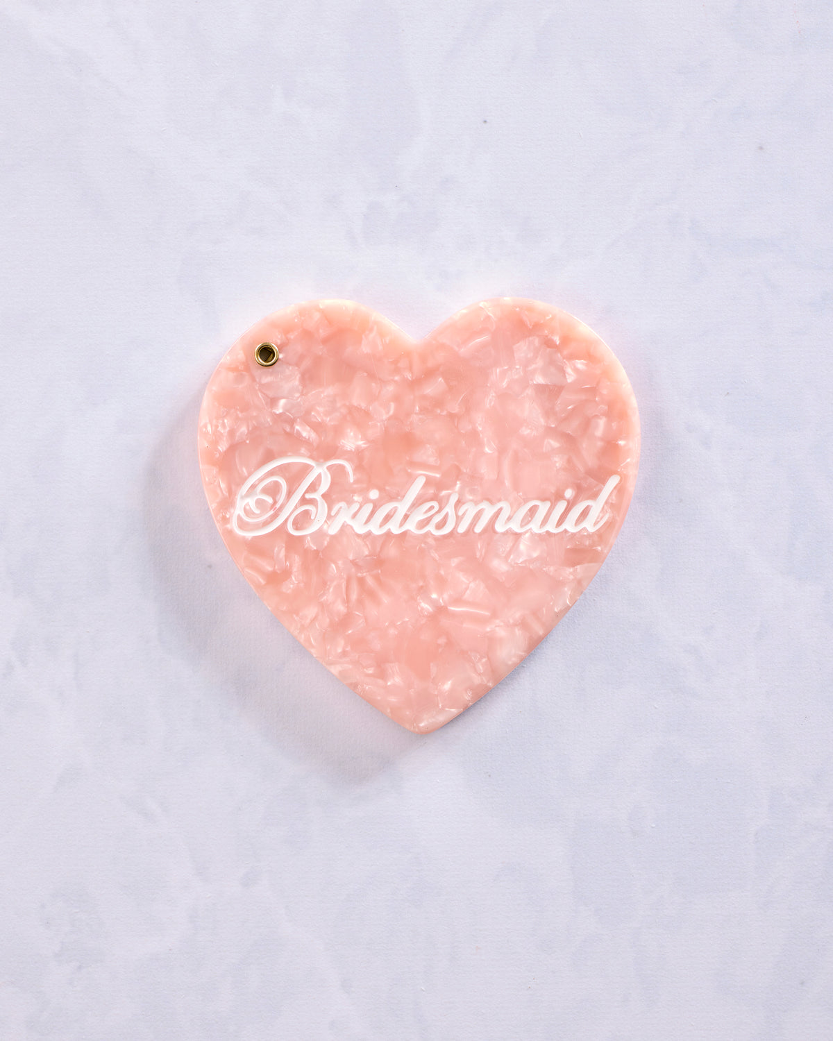 Closed heart-shaped compact mirror with a pink marbled exterior and “Bridesmaid” printed across the front.