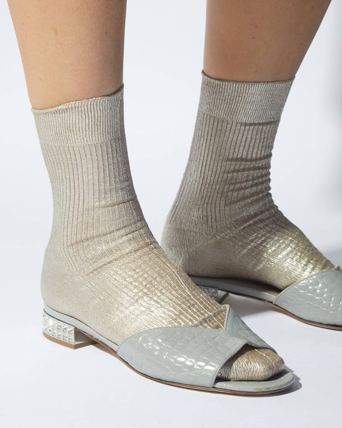Pair of ribbed metallic-finish socks worn with open-toe sandals