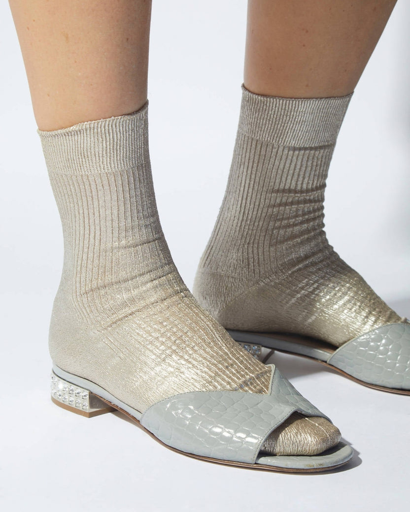 Pair of ribbed metallic-finish socks worn with open-toe sandals