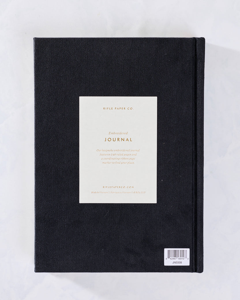 Back cover of the black embroidered journal with a centered product information card and barcode label.