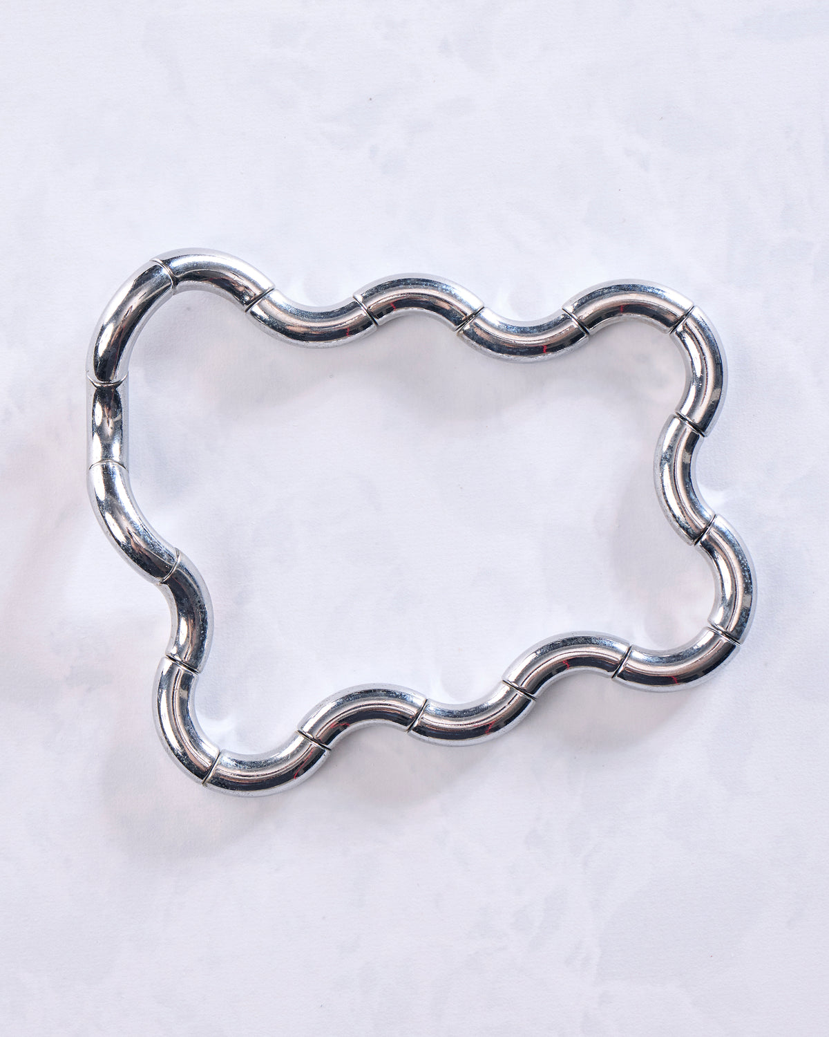 Silver Tangle kinetic metal sculpture extended into a wavy rectangular loop.