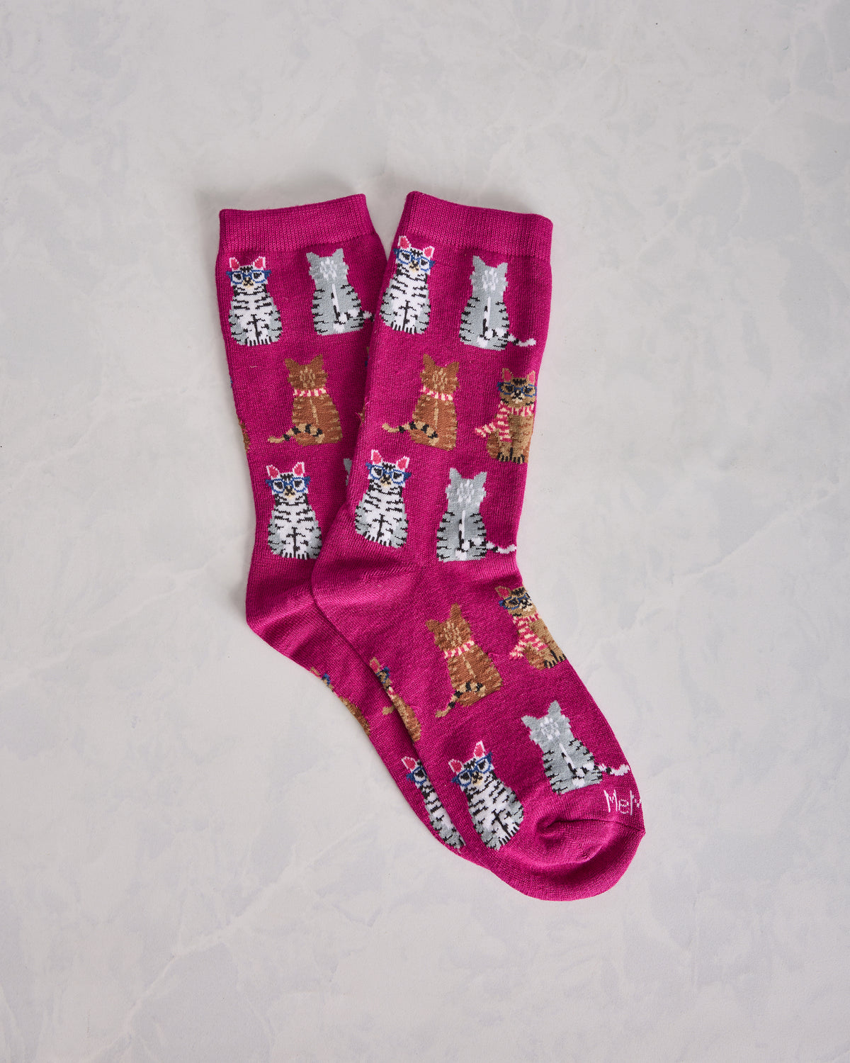 Pair of fuchsia crew socks with repeating illustrated cat designs.