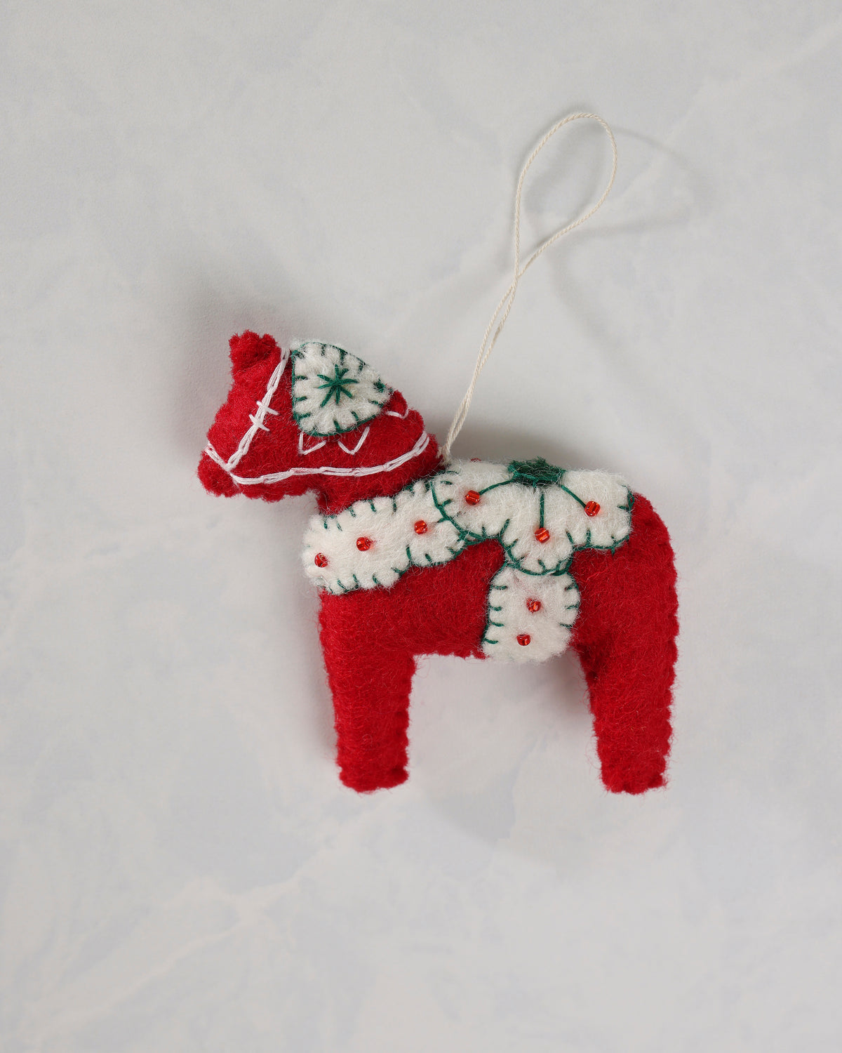 Red and ivory dala horse ornament with a hanging loop