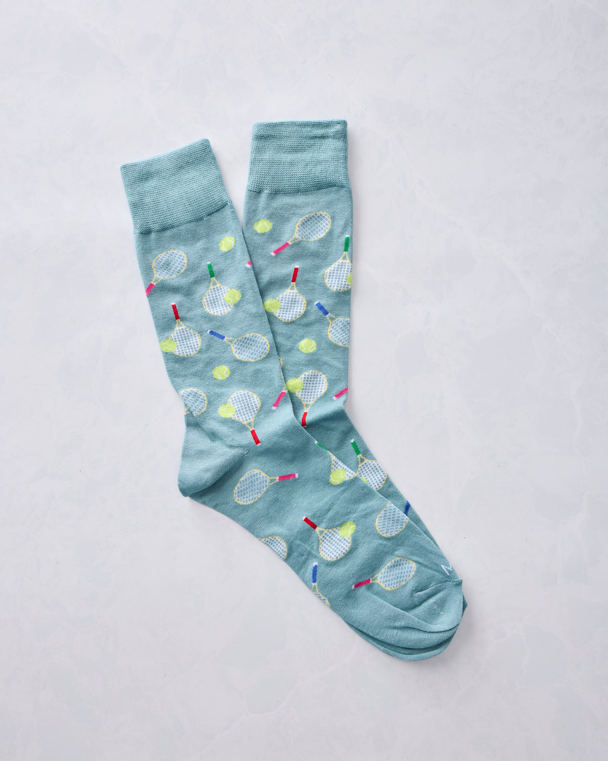 Overlapping blue crew socks with tennis racket and ball print