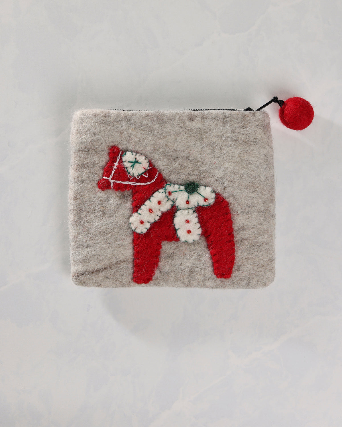 Front view of the ivory Dala horse purse with a red horse applique and red ball zipper pull.