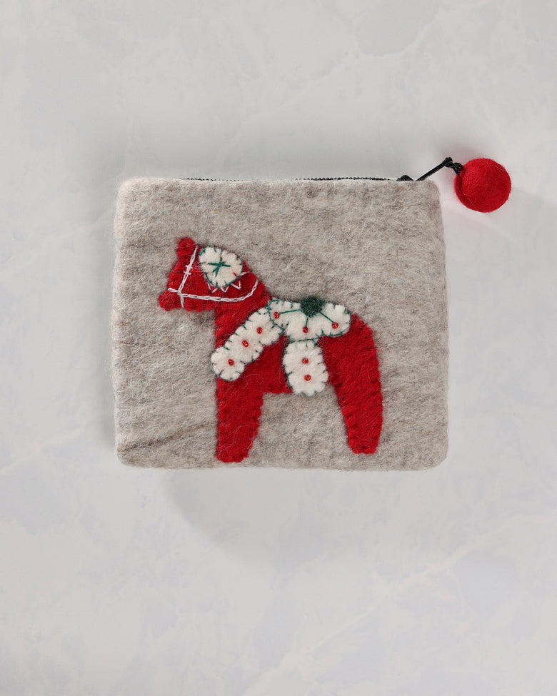 Front view of the ivory Dala horse purse with a red horse applique and red ball zipper pull.