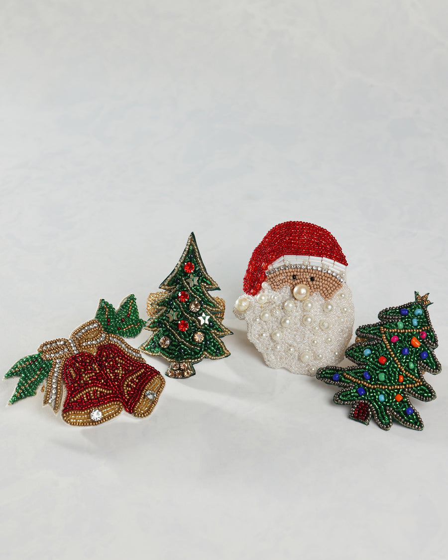 Group of beaded holiday napkin rings featuring bell, Christmas tree, and Santa designs.