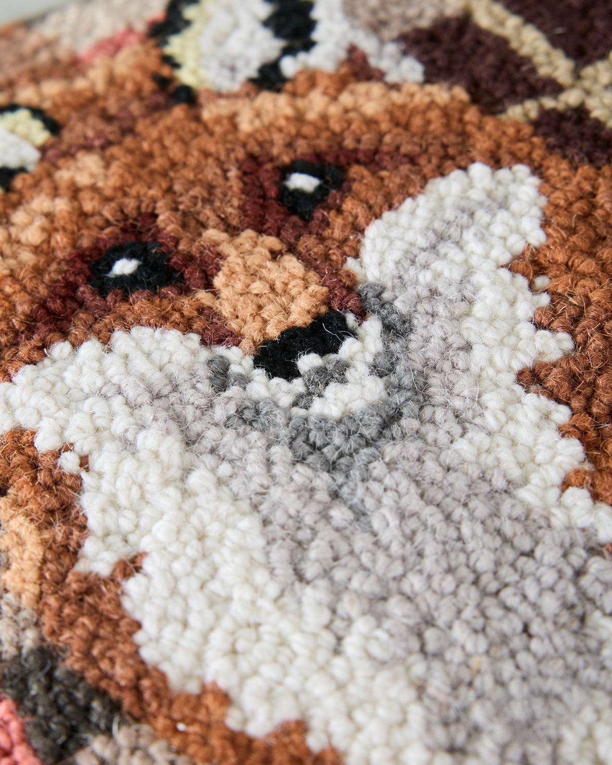 Close-up of the hooked pillow’s fox design, showing raised looped fibers and the fox’s face and white chest.