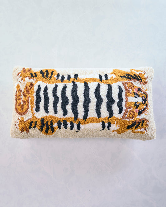 Front view of the Tibetan tiger lumbar pillow with a central striped tiger design and tiger faces at both ends.