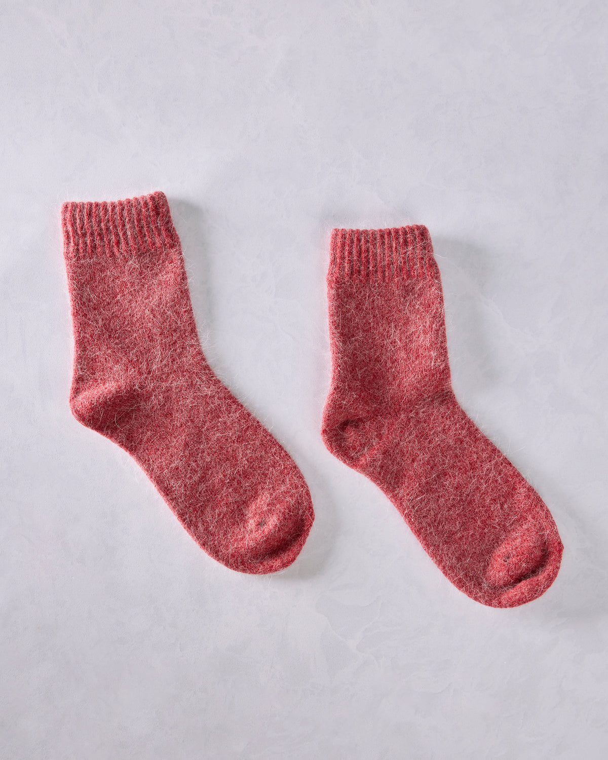 Two red crew socks displayed separately on a light background.