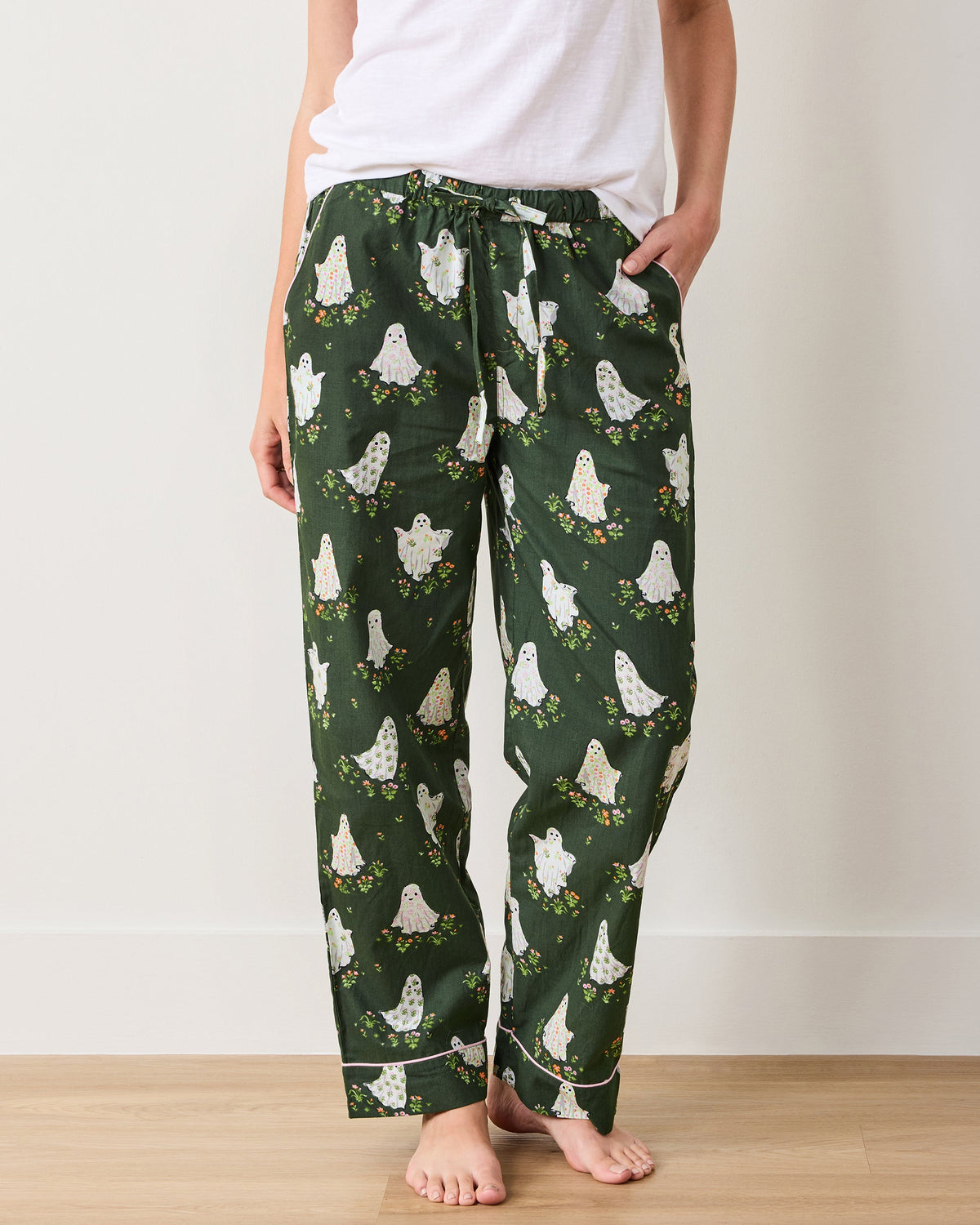 Front view of Gardening Ghosts pajama pants showing the full length, drawstring waistband, pockets, cuffs, and ghost-and-flower print.
