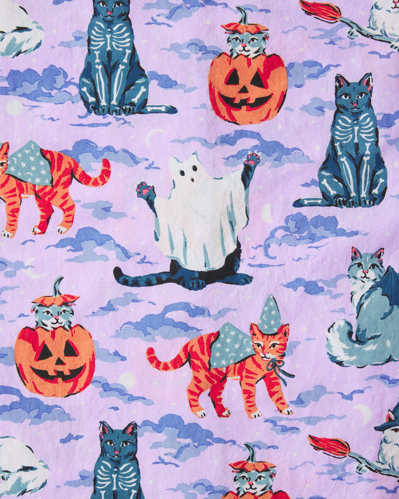 Lavender Halloween House Cats pajama print with black cats, pumpkin-headed cats, orange tabby cats in witch hats, and a white ghost among purple clouds.