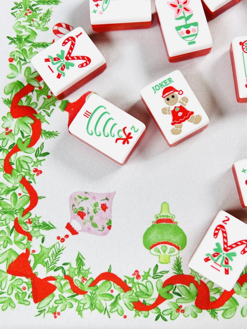 Close-up of the Holly Jolly Christmas Mahjong mat with holiday-printed Mahjong tiles, including a candy cane, ornament, and joker tile.